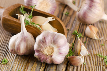 garlic cloves on wood table kitchen painkillers