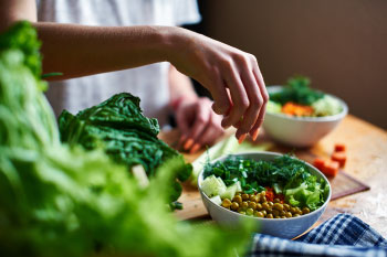 woman making a salad ways fight fatigue