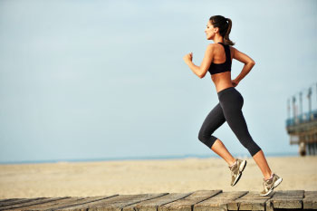 fit woman running on beach