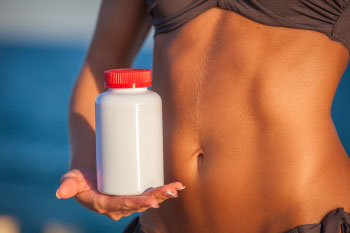 skinny girl holding diet pills