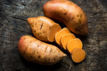 sweet potatoes on wood background