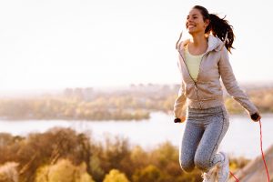 woman jumping rope outside by river